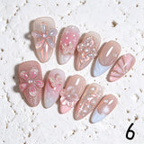 Amourwa luxury handmade 3D bow press-on nails display. Features stunning pastel pink blush and glitter gradient almond nails decorated with oversized 3D resin butterfly bows, delicate white pearl embellishments, and a trendy Y2K coquette aesthetic manicure design.