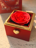 Red preserved rose jewelry gift box with a rotating golden hexagon clasp revealing a customized heart necklace inside.